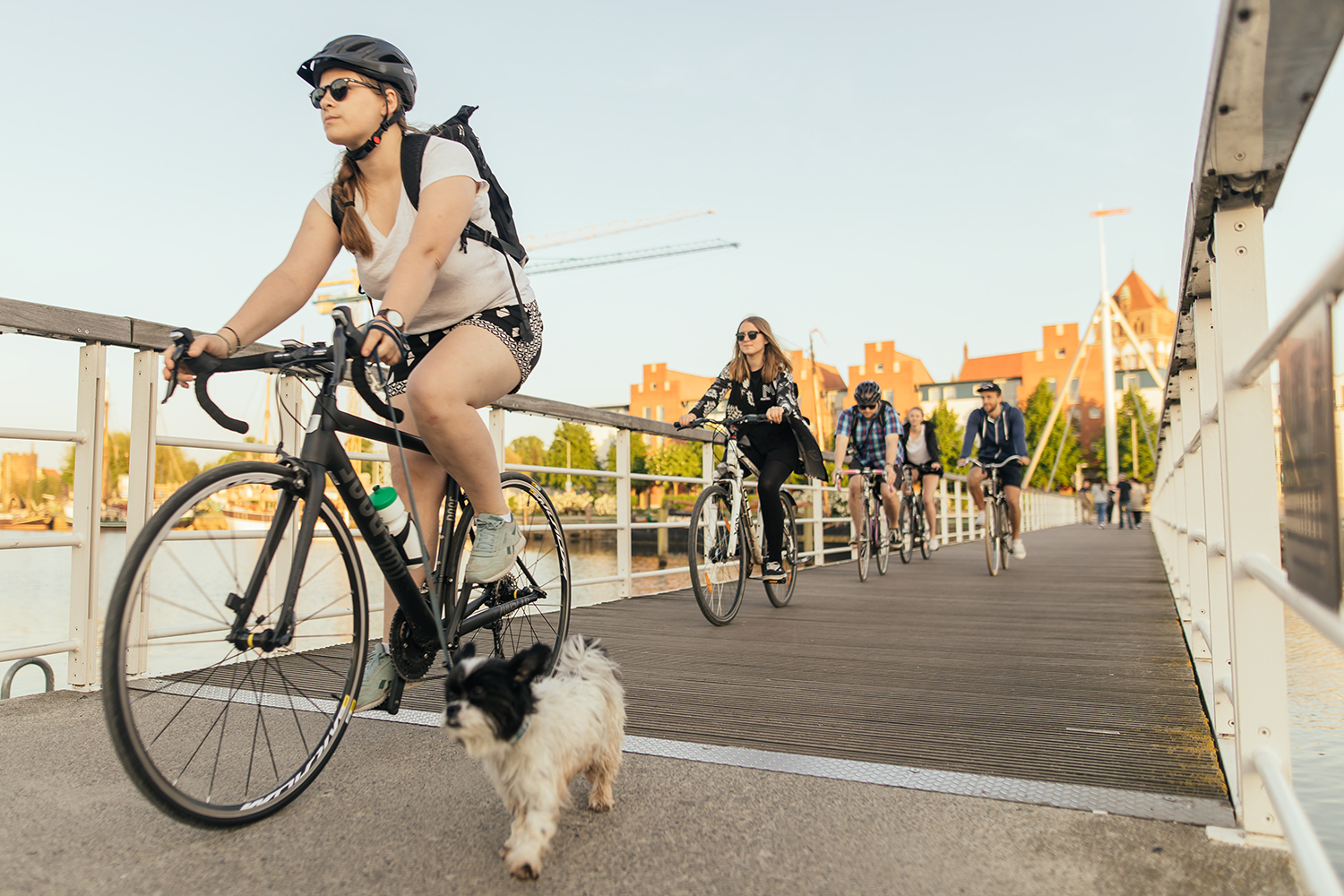 Eine Gruppe von Radler*innen fährt über die Brücke im Museumshafen.